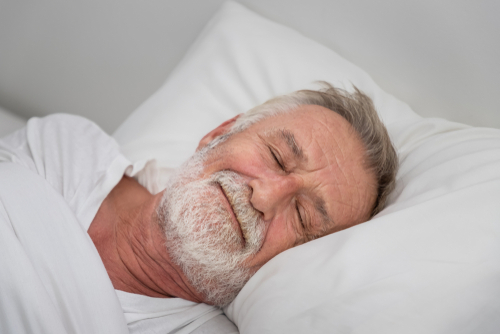 Senior,Elderly,Man,Sleeping,Happily,With,White,Blanket,In,Bedroom